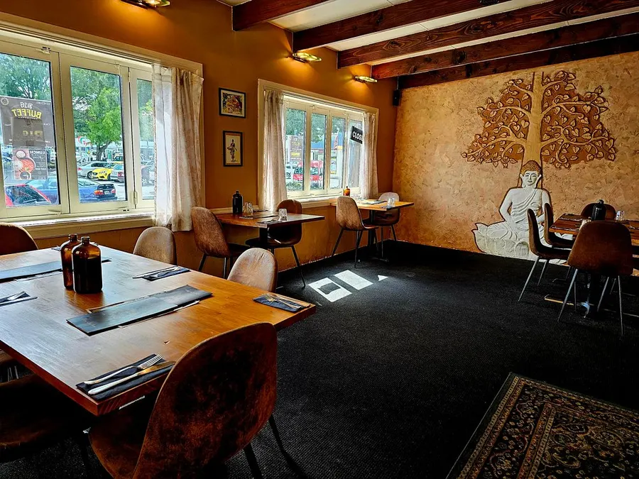 Dining room with hand-carved Buddha mural at Curry Culture Indian Kitchen & Bar